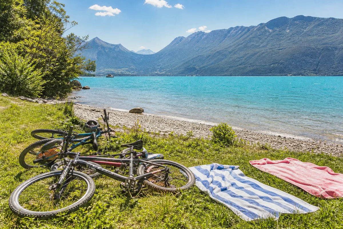 Vélos garés près d’une plage du lac d’Annecy pendant une pause baignade