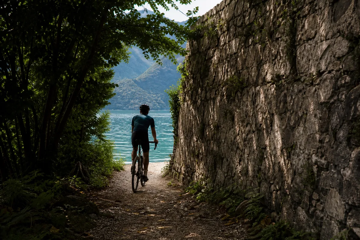 Cycliste ralentissant à l’approche d’un passage étroit ombragé au bord du lac